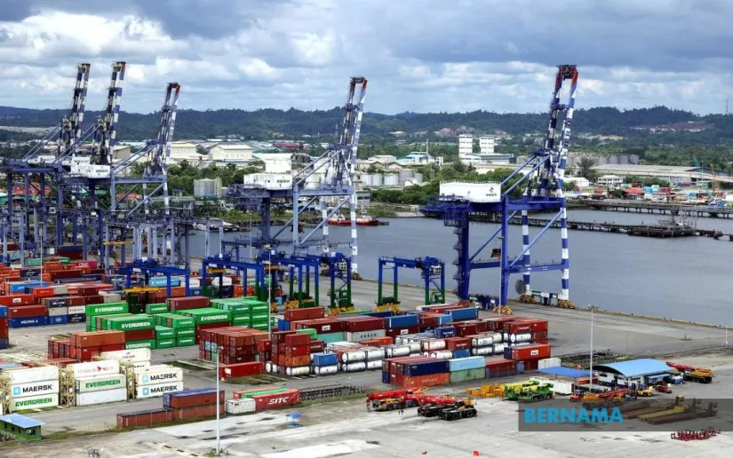 Commercial cargo vessels alongside port cranes