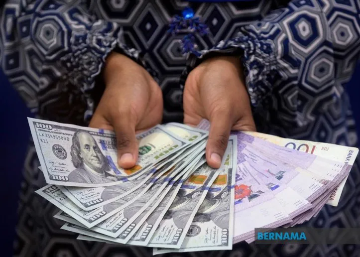 Malaysian ringgit banknotes beside US dollar banknotes