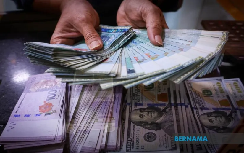 Malaysian ringgit banknotes beside US dollar notes