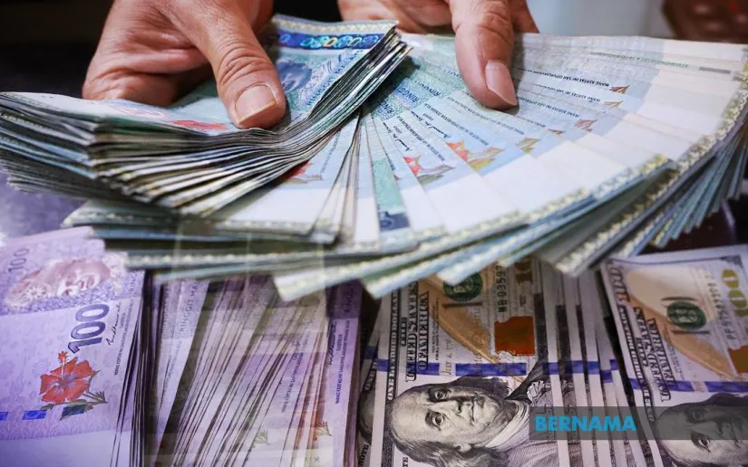 Malaysian ringgit banknotes beside US dollar banknotes