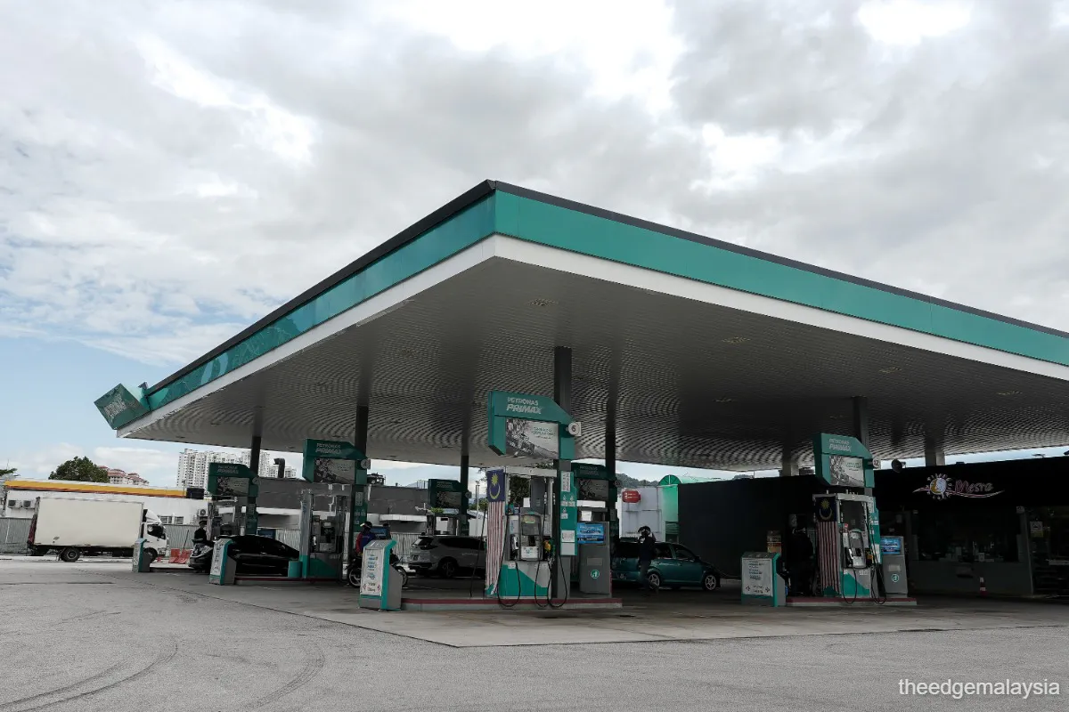 A petrol station forecourt with fuel pumps and a service building