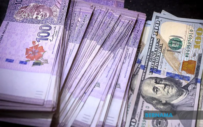 Malaysian ringgit banknotes beside US dollar banknotes