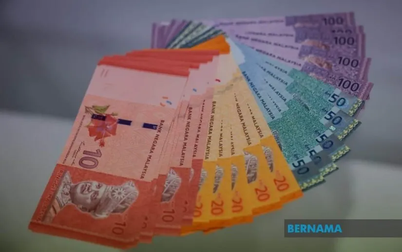 Malaysian ringgit banknotes beside US dollar banknotes